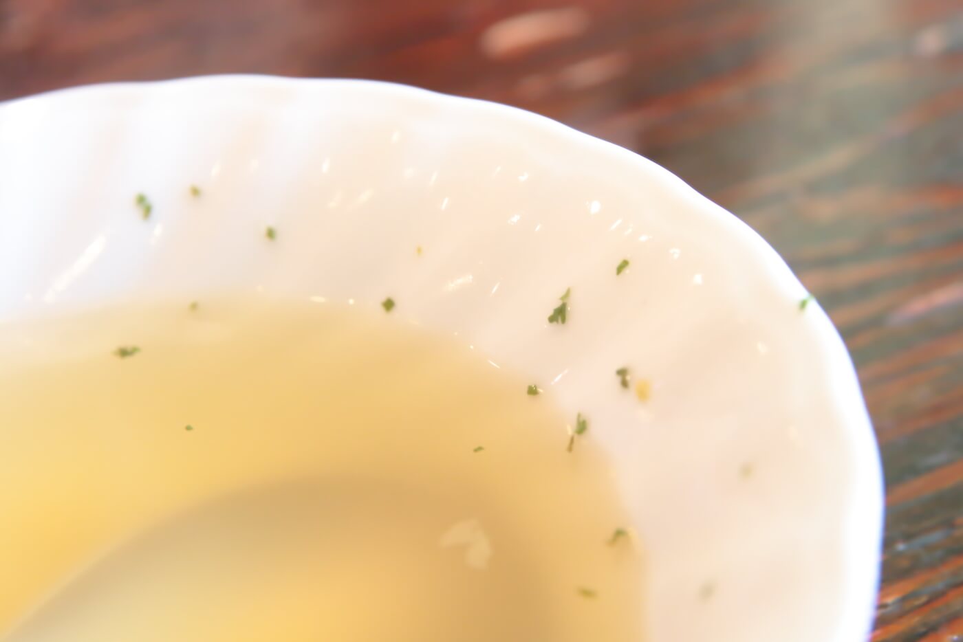 高知市の鶏料理屋さん 鳥心 コンソメスープの皿の脇に散らされたパセリ